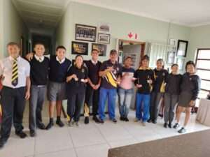Learners standing at entrance to Langebaan Primary School, receiving their price for the school