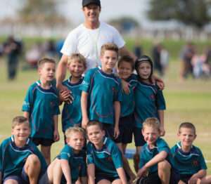 Teacher with school rugby team , standing together for team photo from Topolino School in Langebaan
