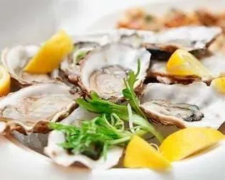Iioysters on a plate decorated with lemon and parsley. Enjoy places to eat when you visit langebaan