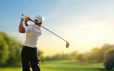 Iia male golfer hits of on the green at the langebaan golf course looking in the direction of his hit. Enjoying golf in langebaan