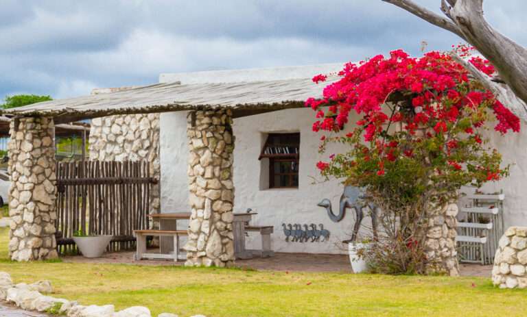 Love weskus ilove weskus ithe self-catering chalets at thali thali game lodge. White cottage with stone finished exterior walls and red bougainvillea that provides colour