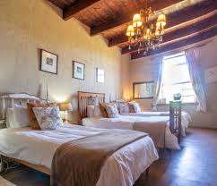 Love weskus ilove weskus ione of the bedrooms in the farmhouse at thali thali game lodge with 3 single beds, wooden floors and ceiling as interior