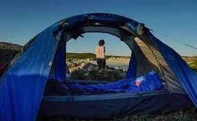 Iilady walks away from open tent that was used as accommodation on the beach in the west coast national park
