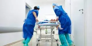 Iiemergency services at hospitals in langebaan, where to staff are pushing a patient in bed in a passage