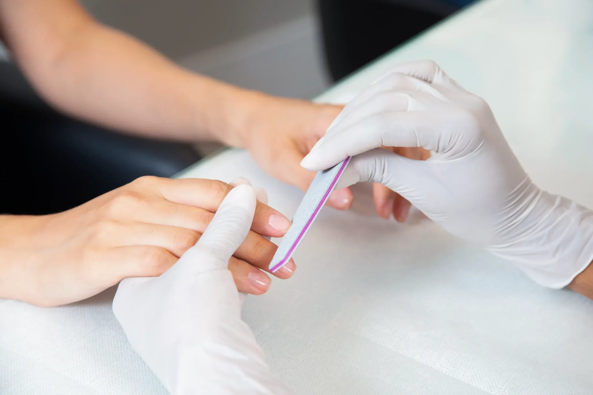Iia client has her nails done by a professional in gloves at nail salons in langebaan