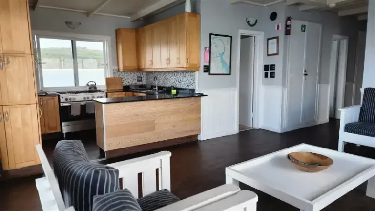 Iithe lounge and kitchen area of the nivana boat house in langebaan with wooden kitchen and seating