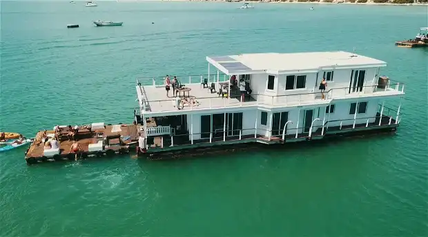 Iithe arial view of the nirvana boat house in langebaan, floating on the lagoon with attached wooden floatable deck for enjoyment