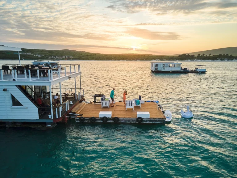 Iiguest are dancing on the floatable deck at sunset onboard the nirvana boat house in langebaan