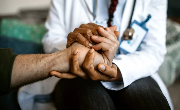Iian assistant is holding the hand of a person providing comfort with support services in langebaan