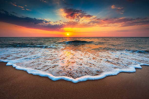 Love weskus ilove weskus ithe sea water wash over the beach sand with white foam with beautiful cloudscape over the sea at sunrise in langebaan