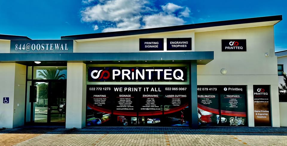 Front of PRINTTEQ printing shop with prominent logo signs and service banners in the windows.