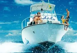 Iiwhite motorboat speeding through turquoise water, with people on the deck enjoying the ride and splashing waves.