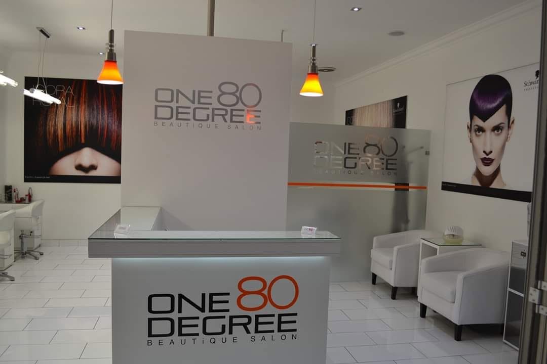 One80 degree beautique salon – – Iireception desk at one 80 degreee beautique salon with white tiled floor, branding signage, and seating area in the background